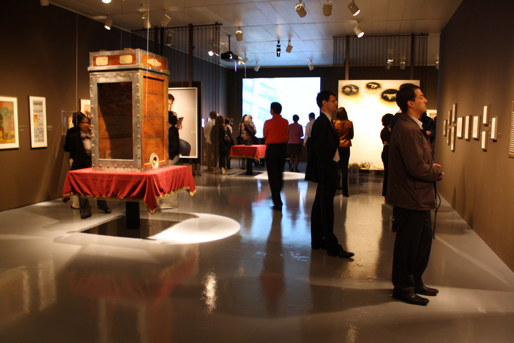 Museum visitors looking at objects on the walls